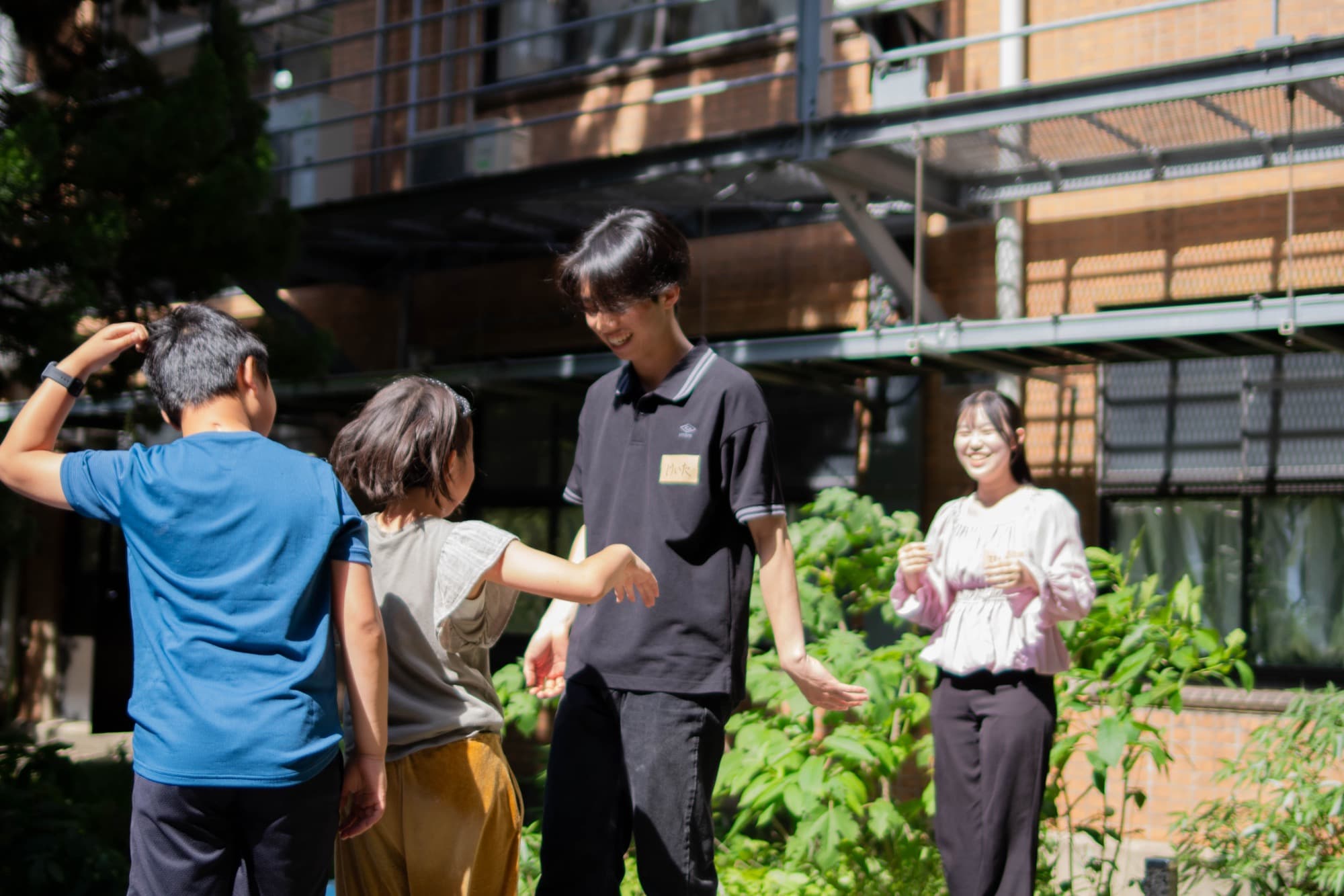 大学のキャンパスで子どもたちと過ごす大学生スタッフ