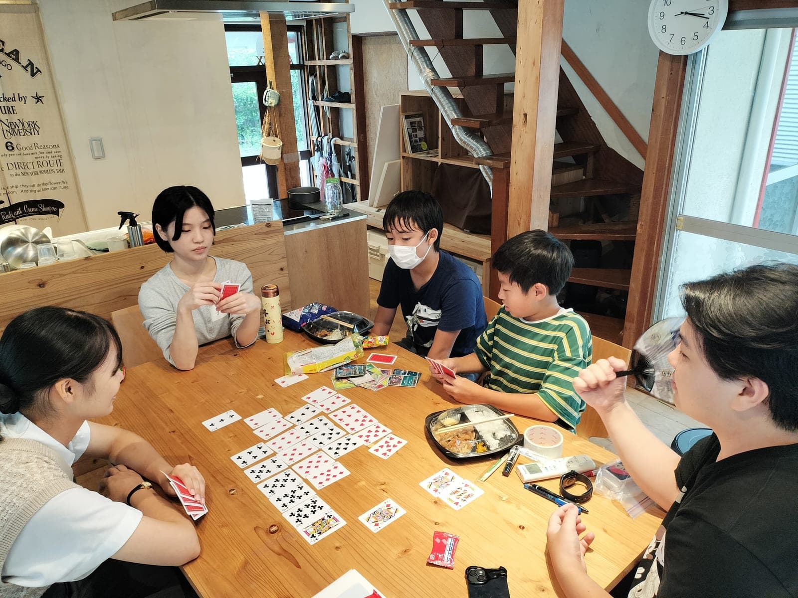 OIKOS八景でトランプをして過ごす子どもと大学生